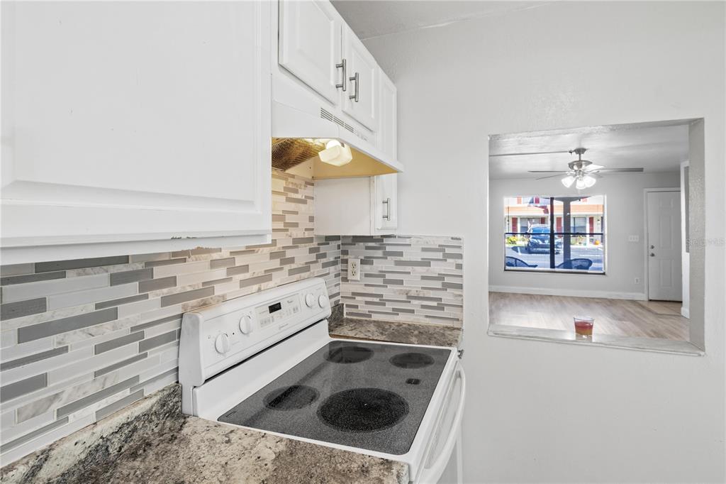 980 Canal View Boulevard, Unit I3 Port Orange, FL 32129 - Photo 7 of 17 a kitchen with granite countertop a sink and a stove