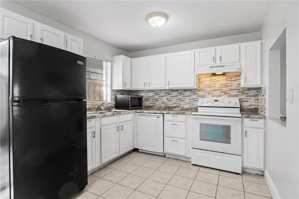 980 Canal View Boulevard, Unit I3 Port Orange, FL 32129 - Photo 8 of 17 a kitchen with white cabinets and refrigerator