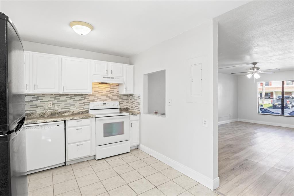 980 Canal View Boulevard, Unit I3 Port Orange, FL 32129 - Photo 9 of 17 a kitchen with granite countertop white cabinets and white appliances