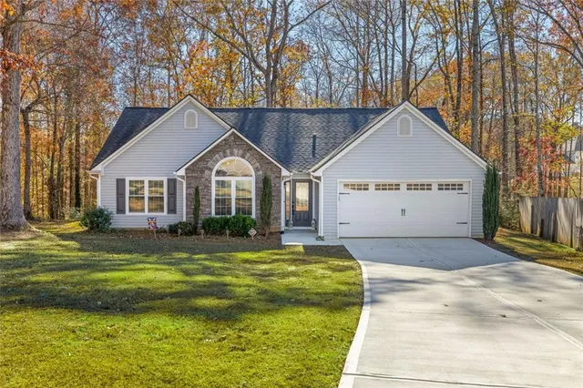 a view of a house with a yard and fence