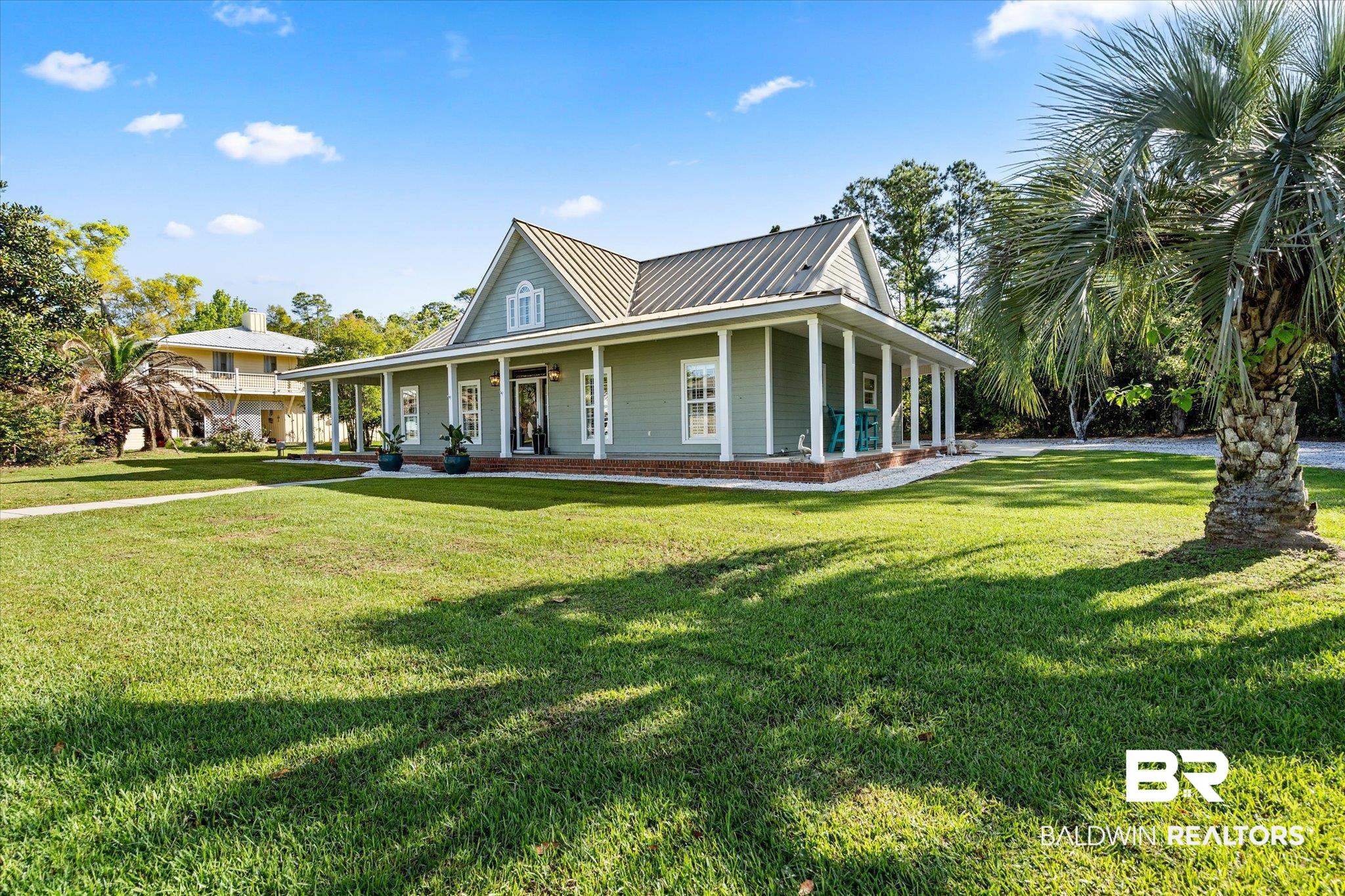 4947 Look Rook Road Orange Beach, AL 36561 - Photo 21 of 24 View of front facade with a front yard, a porch, and metal roof