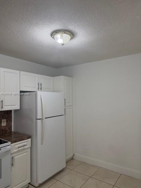 8781 Wiles Road, Unit 103 Coral Springs, FL 33067 - Photo 11 of 19 a white refrigerator freezer and a stove sitting inside of a kitchen