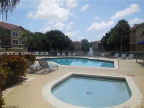 8781 Wiles Road, Unit 103 Coral Springs, FL 33067 - Photo 4 of 19 a view of a swimming pool with a yard and sitting area