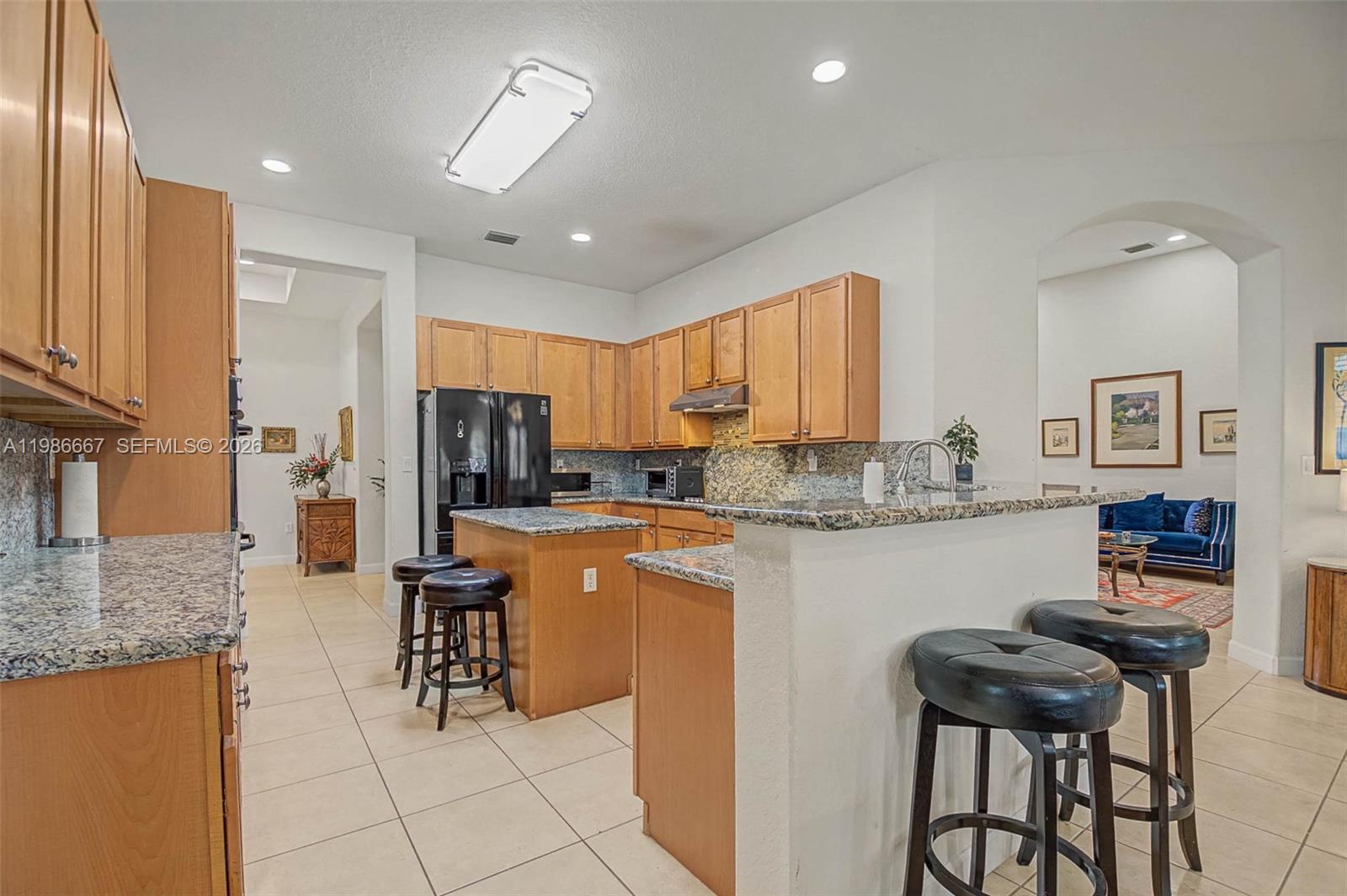 19528 Southwest 79th Place Cutler Bay, FL 33157 - Photo 13 of 41 a kitchen with stainless steel appliances granite countertop a stove top oven a sink a dining table and chairs