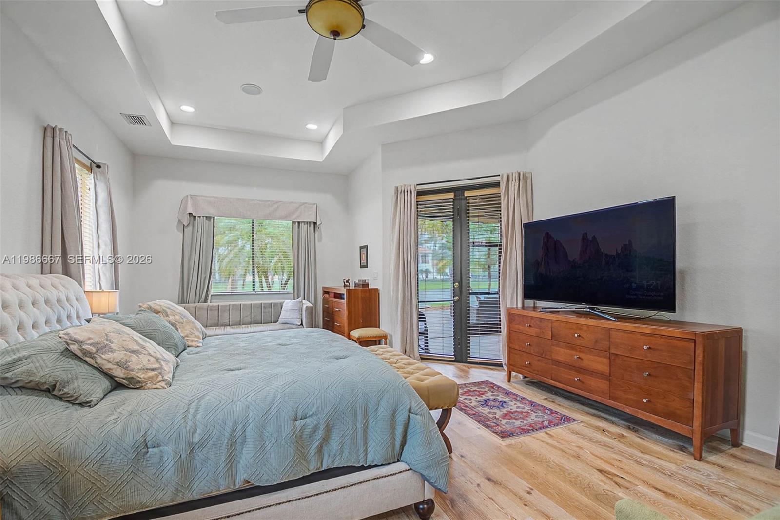 19528 Southwest 79th Place Cutler Bay, FL 33157 - Photo 6 of 41 a bedroom with a large bed and a flat screen tv on dresser