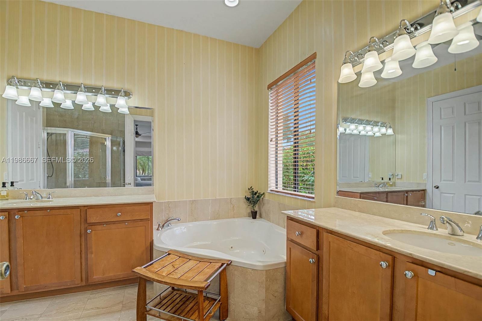19528 Southwest 79th Place Cutler Bay, FL 33157 - Photo 8 of 41 a bathroom with a granite countertop sink a large mirror and a bathtub