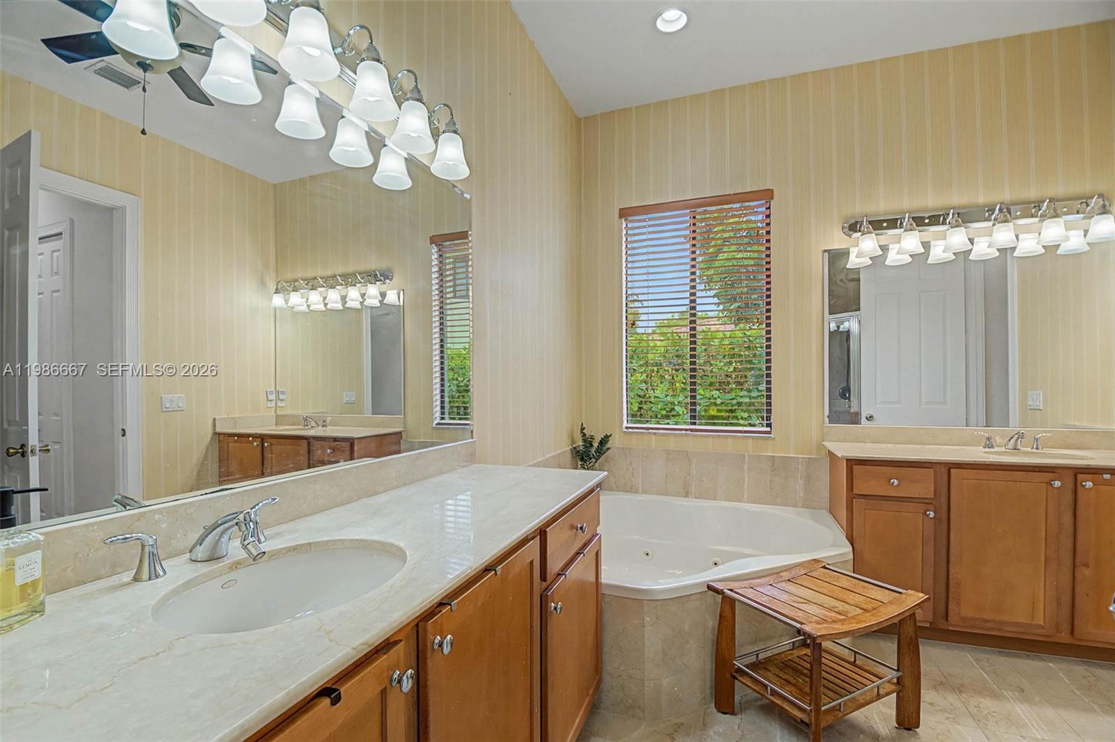 19528 Southwest 79th Place Cutler Bay, FL 33157 - Photo 9 of 41 a spacious bathroom with a granite countertop sink a large mirror and a bathtub with shower