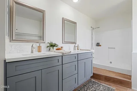 a bathroom with double sink and a mirror