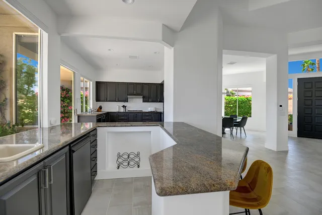a kitchen with stainless steel appliances granite countertop sink stove refrigerator and cabinets