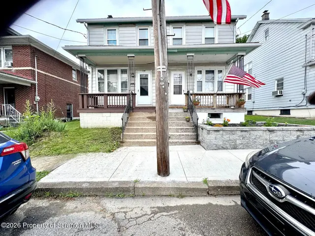 a view of a brick building with a yard and sitting area