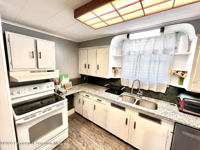 a kitchen that has a sink a stove and a wooden floors