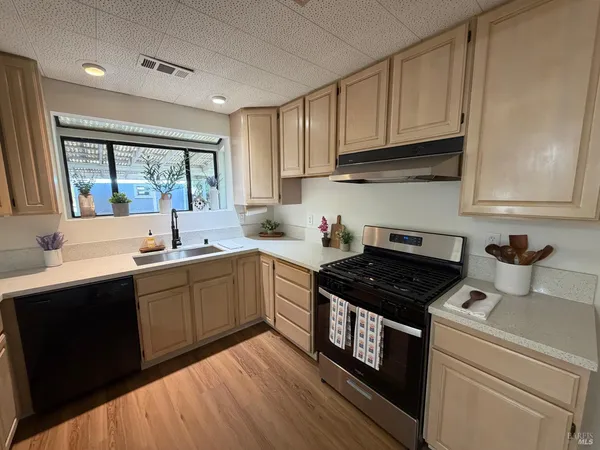 a kitchen with a sink stove top oven and cabinets