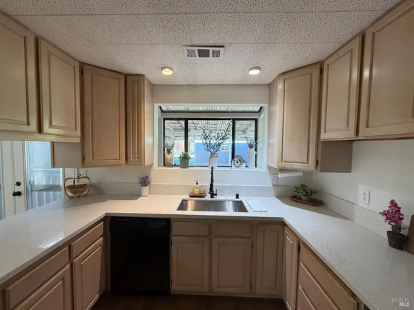 a kitchen with a sink cabinets and window