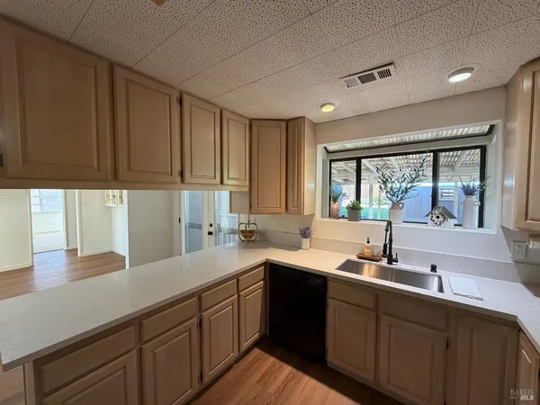 a kitchen with a sink window and cabinets