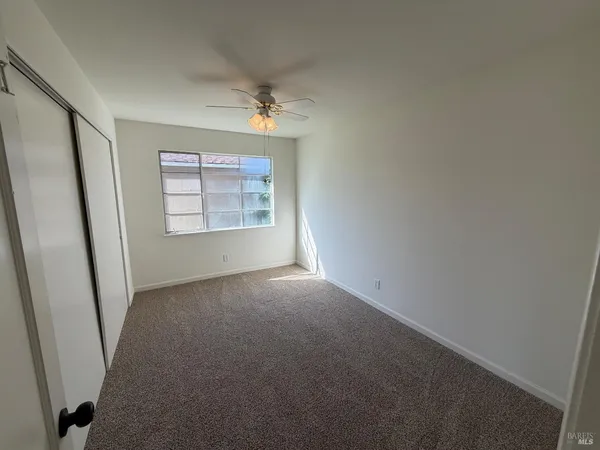 an empty room with windows and cabinet