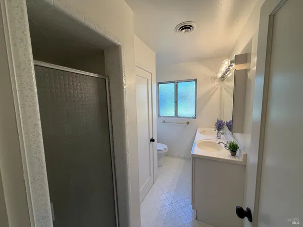 a bathroom with a granite countertop sink toilet and mirror