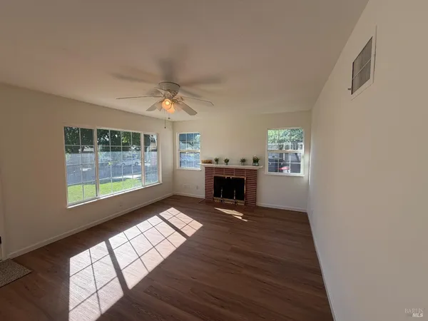 a view of an empty room with a fireplace and a window