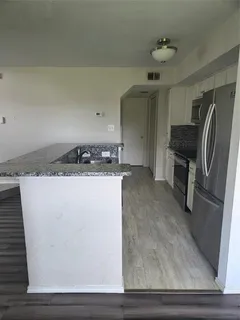 a kitchen with a sink a refrigerator and cabinets