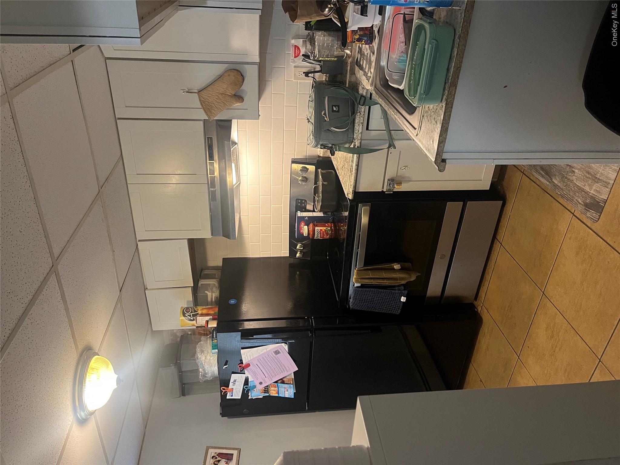 57 Aloma Road Rocky Point, NY 11778 - Photo 4 of 5 a kitchen with a refrigerator and cabinets