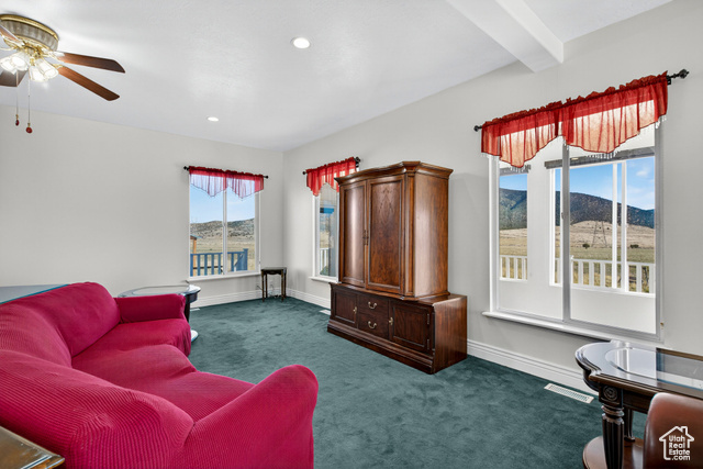 4768 East Hickman Canyon Road Stockton, UT 84071 - Photo 21 of 85 Living room with carpet, beamed ceiling, recessed lighting, a mountain view, and ceiling fan.