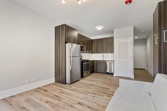 a kitchen with stainless steel appliances a refrigerator and a wooden cabinets