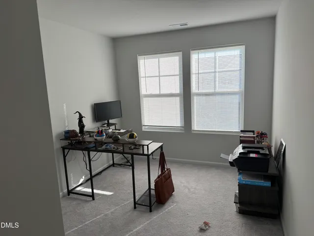 a view of a workspace with furniture and a window