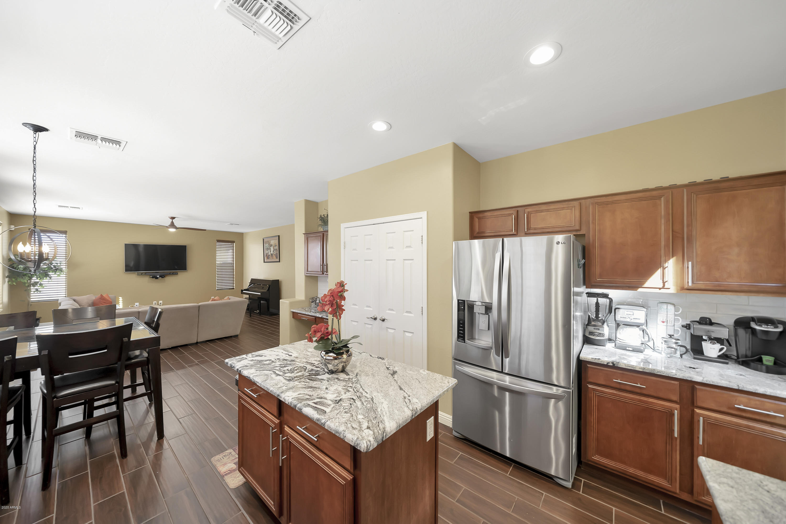 14103 West Bloomfield Road Surprise, AZ 85379 - Photo 14 of 51 a kitchen with stainless steel appliances kitchen island granite countertop a refrigerator stove microwave and wooden floor