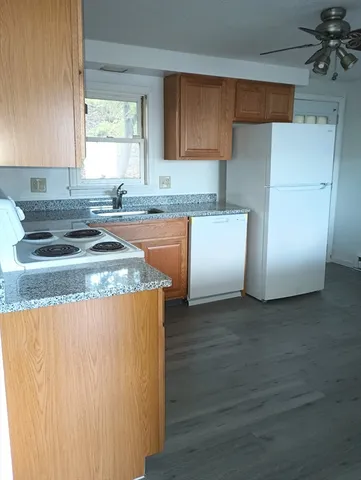 a kitchen with granite countertop white cabinets and white appliances