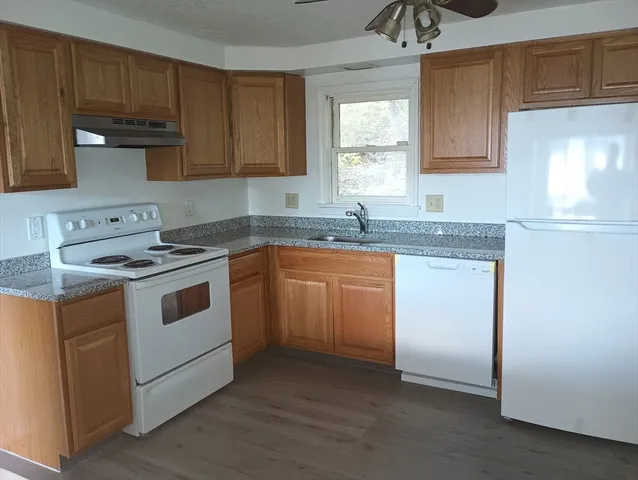 a white kitchen with granite countertop stainless steel appliances