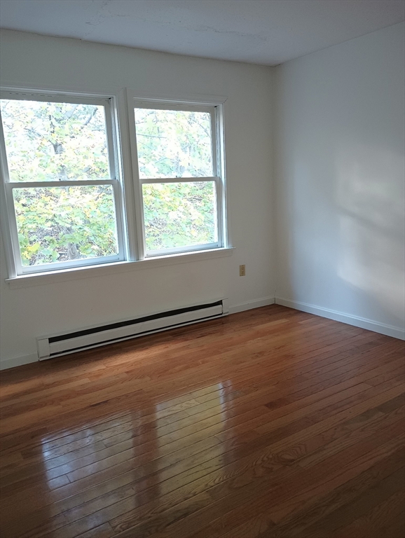 20-3 Rice Lane Worcester, MA 01604 - Photo 7 of 12 an empty room with wooden floor and windows