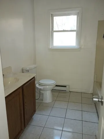 a bathroom with a sink a toilet and a window