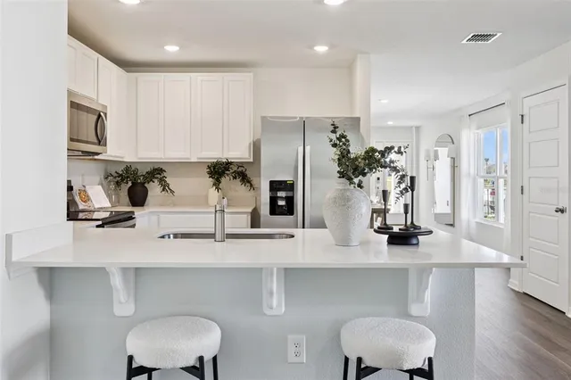 a kitchen with stainless steel appliances a sink and a refrigerator