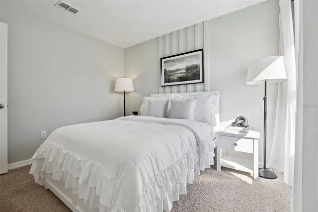 a bedroom with a bed and a lamp