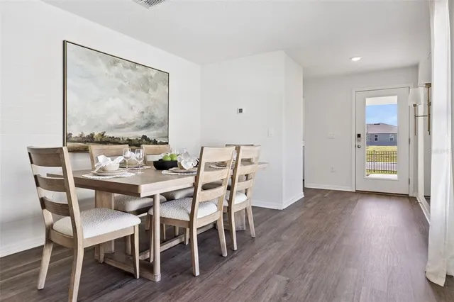 a dining room with furniture window and wooden floor