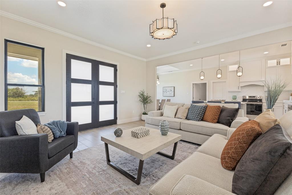 3150 Crisp Road Ennis, TX 75119 - Photo 4 of 30 Spacious open-concept living area featuring a modern chandelier, recessed lighting, and crown molding