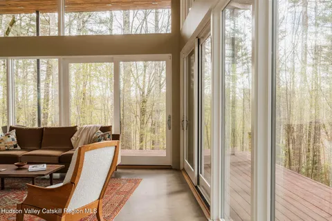 a living room with furniture and a floor to ceiling window