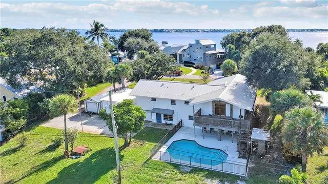 an aerial view of a house with swimming pool garden and patio