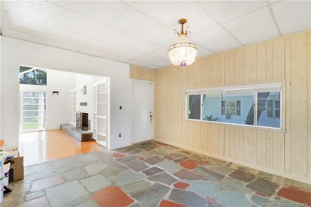 a view of a hallway with wooden floor and a chandelier