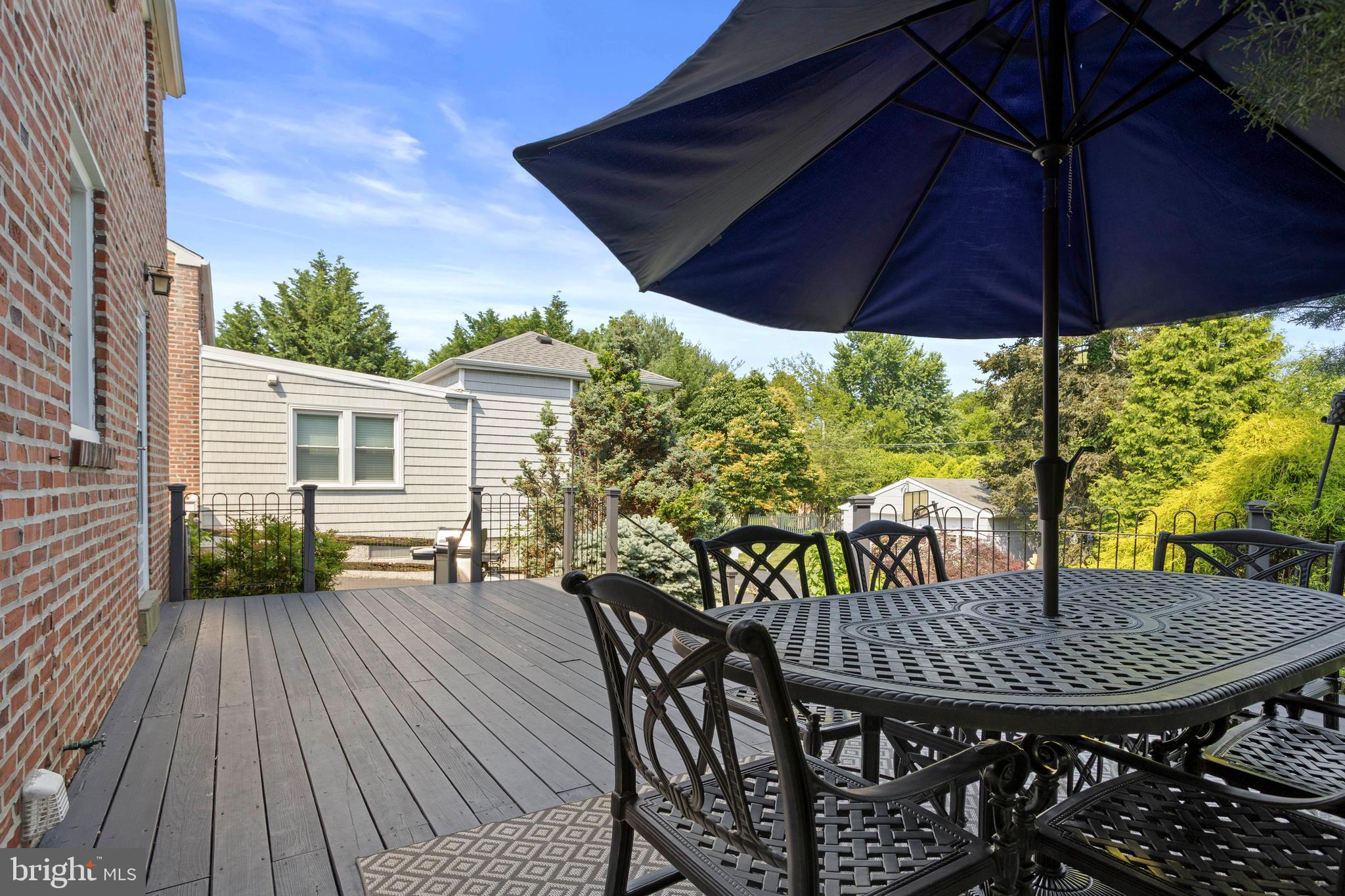 46 Plymouth Road Springfield, PA 19064 - Photo 25 of 30 a view of a patio with table and chairs under an umbrella with wooden floor