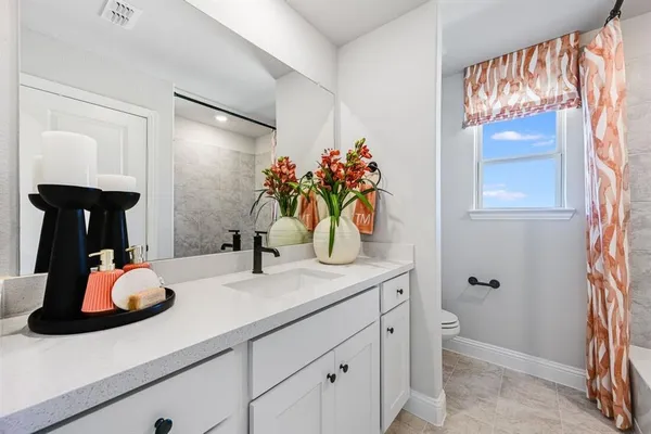 a bedroom with a large bed chandelier and a window