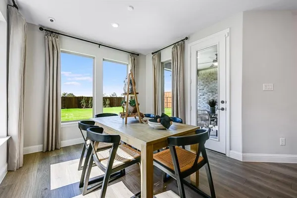 a living room with furniture kitchen view and a wooden floor