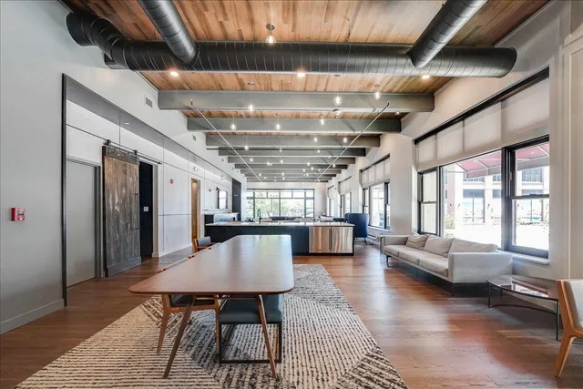 a dining room with furniture a chandelier and wooden floor