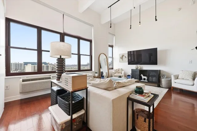a living room with furniture a flat screen tv and a large window