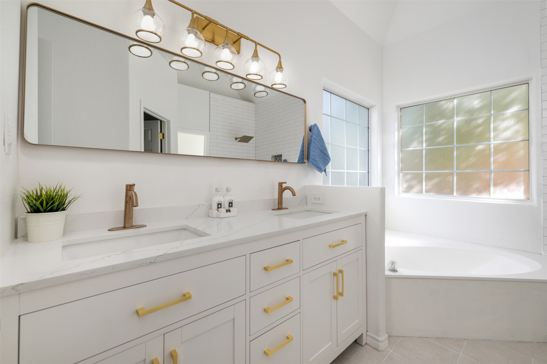 72 Crazy Cross Road Wimberley, TX 78676 - Photo 20 of 35 Gold fixtures accent the clean white vanity and built-in tub under a high ceiling.