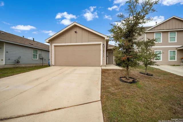 a view of an house with backyard and trees