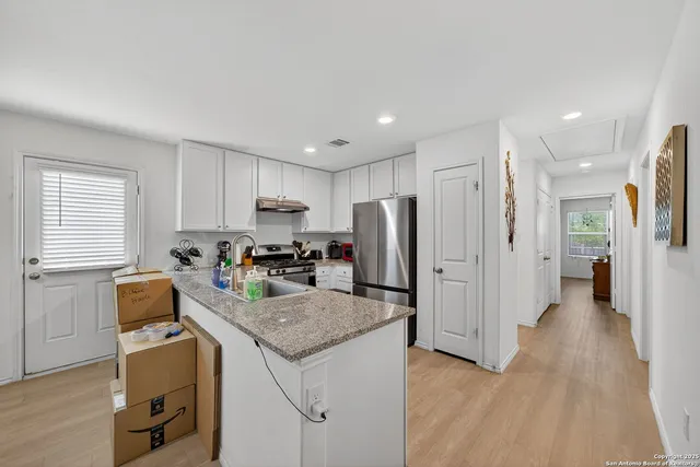 a kitchen with stainless steel appliances granite countertop a sink stove and refrigerator