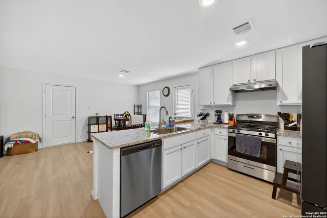 a kitchen with stainless steel appliances granite countertop a sink stove and refrigerator