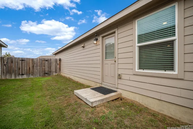 a view of a yard with wooden fence