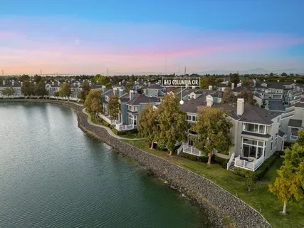 an aerial view of ocean and residential houses with outdoor space