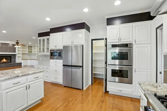 a kitchen with a refrigerator and a stove top oven